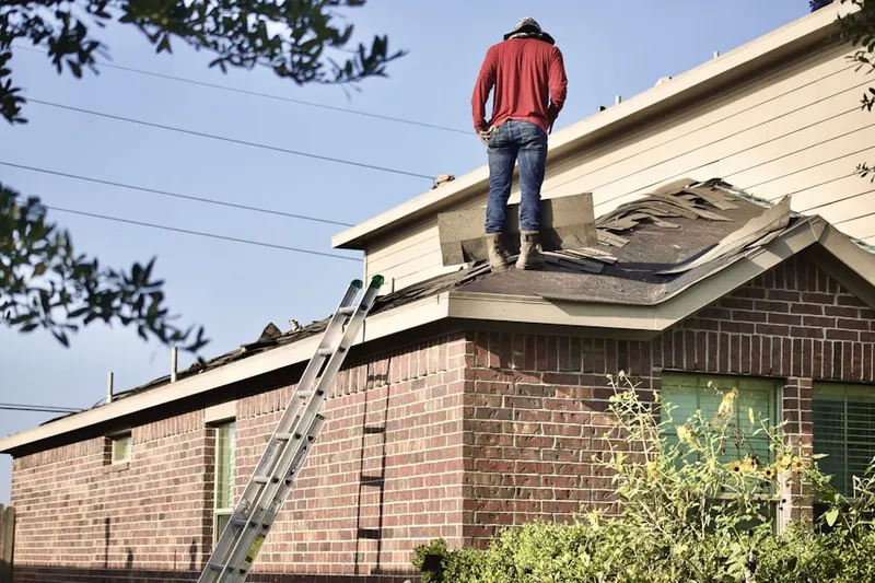 Professional roofer working on a residential roof in Millport